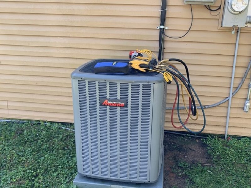 Refrigerant manifold gauges connected to an Amana condenser beside the electric meter and disconnect at a Van Buren, AR home